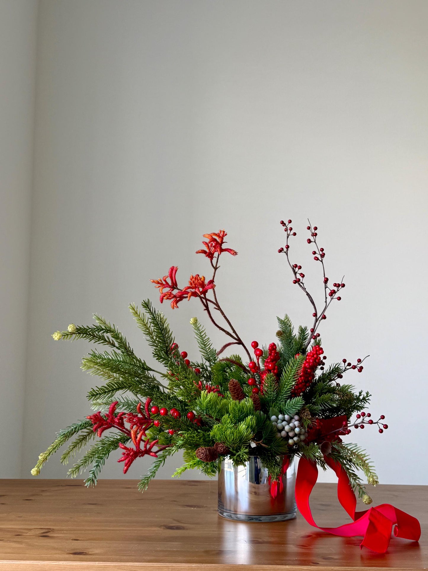 Artificial Christmas Centerpiece with Pine Greenery Berries and Red Ribbon in Glass Vase